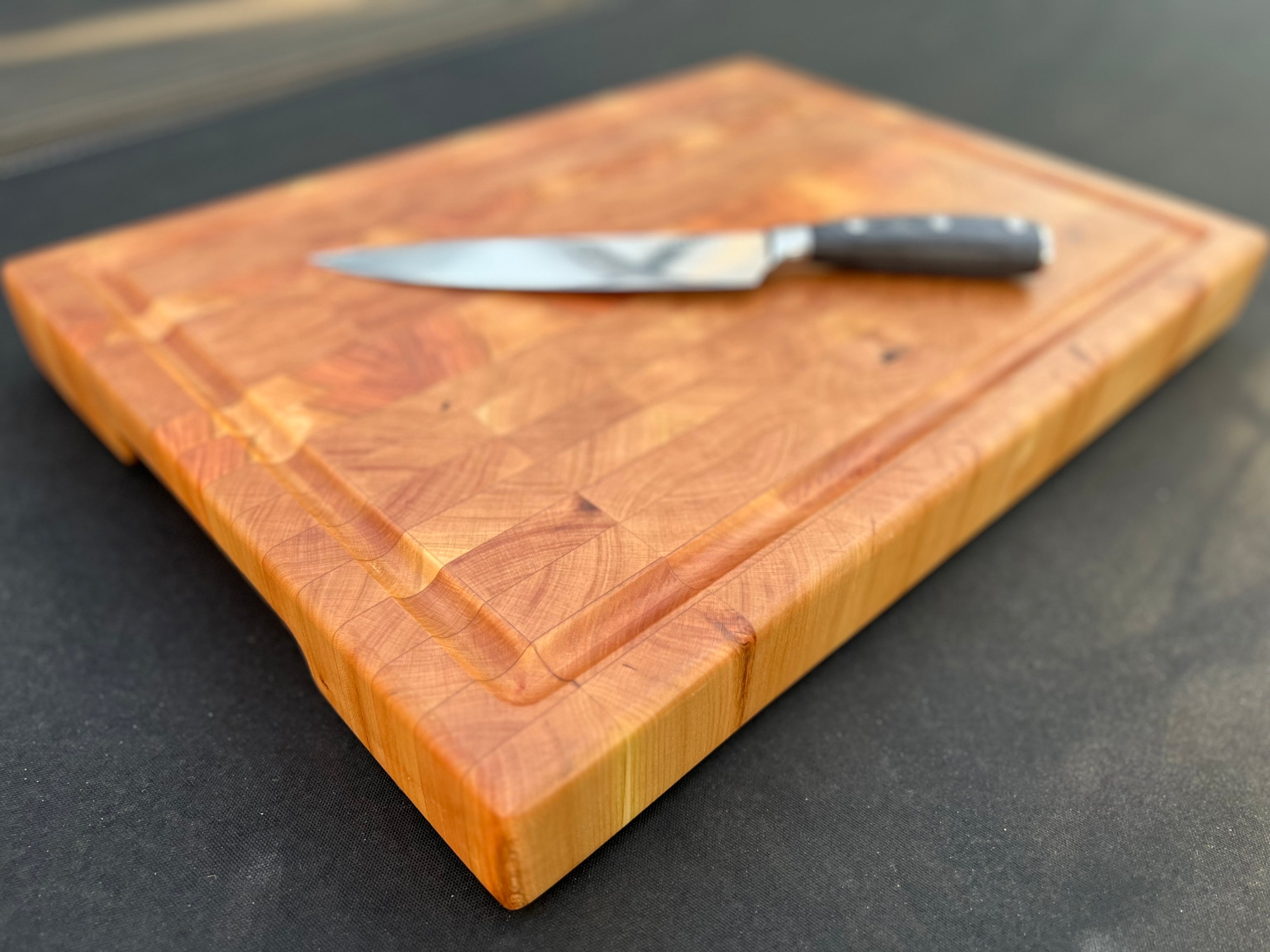 Cherry cutting board with a smooth, rich finish, highlighting the wood's natural warmth and grain pattern.