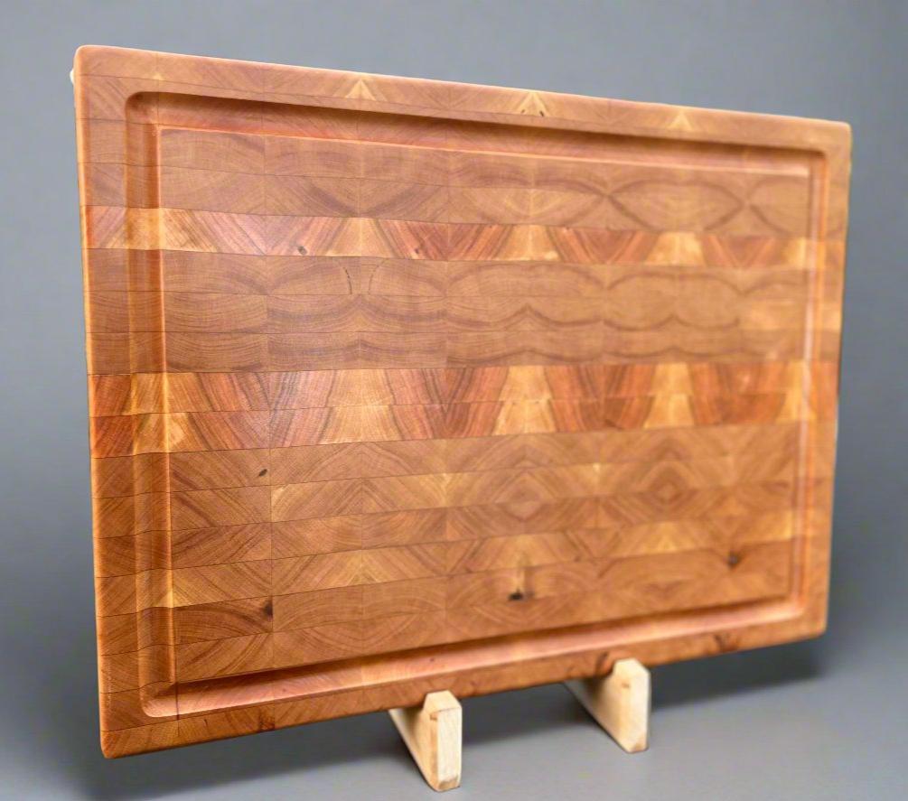 Cherry cutting board with a smooth, rich finish, highlighting the wood's natural warmth and grain pattern.