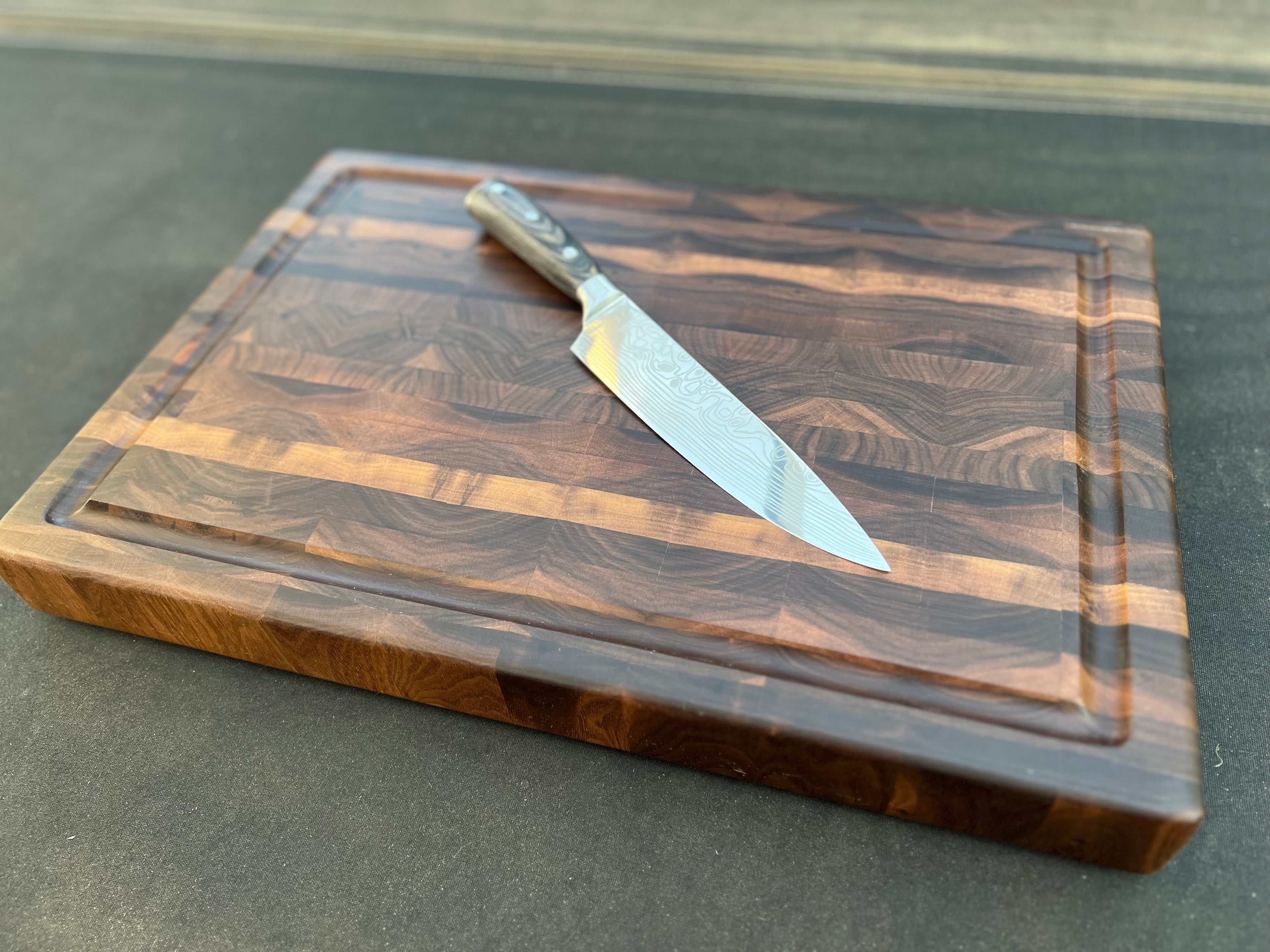 Walnut cutting board featuring a dark, elegant finish and rich wood grain, ideal for stylish and durable kitchen use.