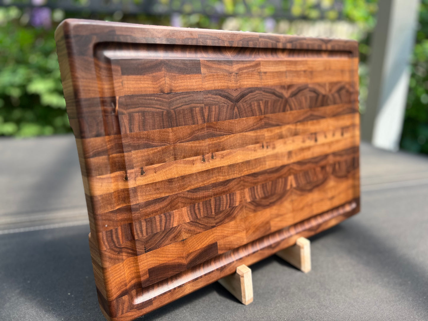 Large end grain walnut cutting board with a robust, textured surface that highlights the rich wood grain and provides durability for heavy use.