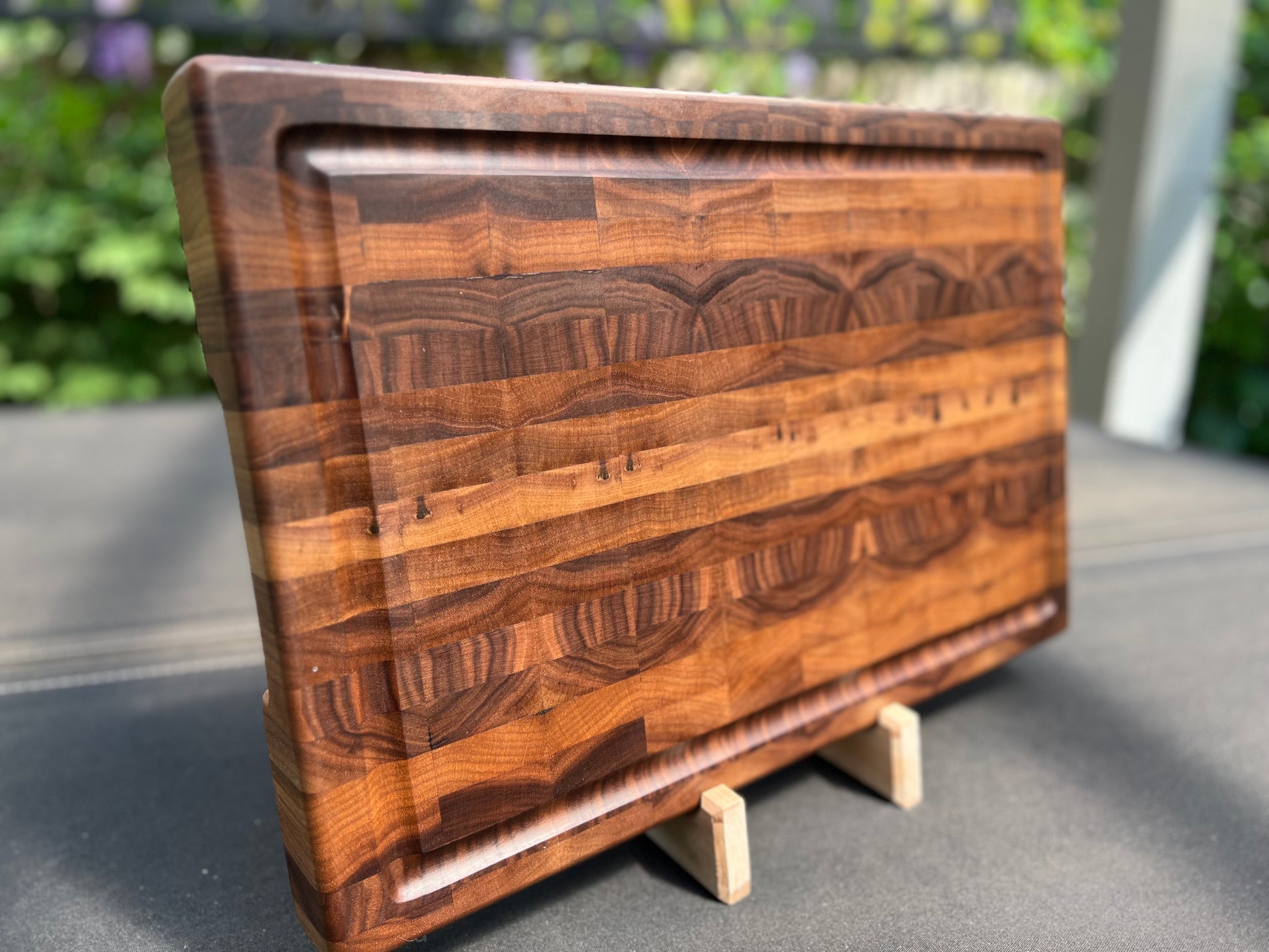 Large end grain walnut cutting board with a robust, textured surface that highlights the rich wood grain and provides durability for heavy use.