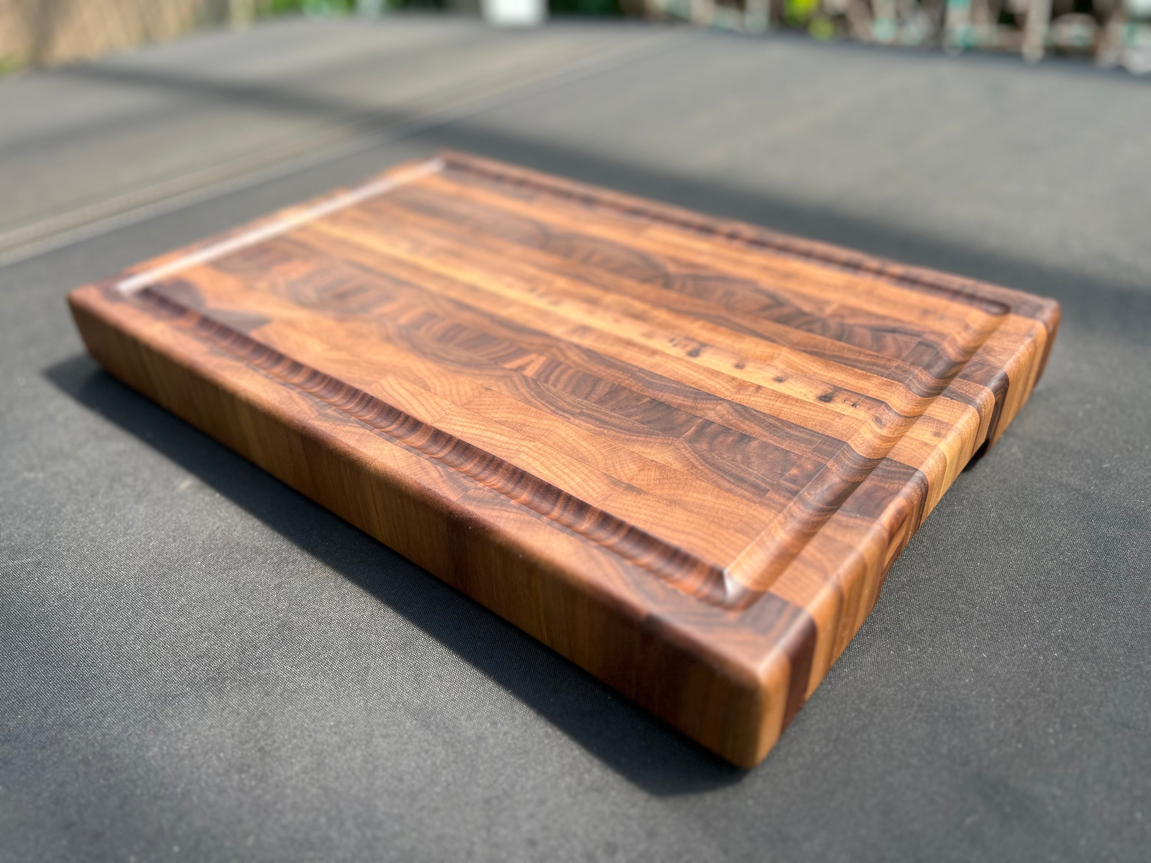 Large end grain walnut cutting board with a robust, textured surface that highlights the rich wood grain and provides durability for heavy use.