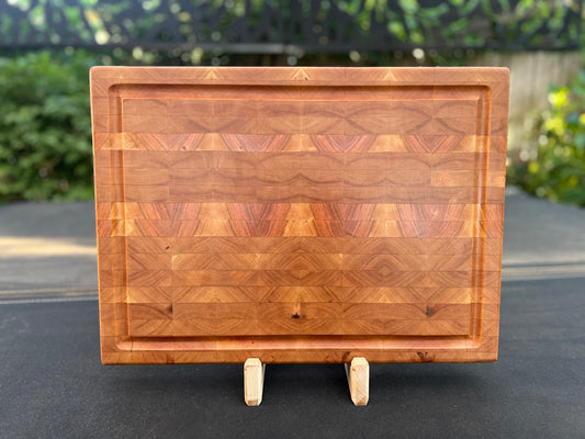 End grain cherry cutting board showcasing a rich, warm wood grain pattern and a sturdy, knife-friendly surface.