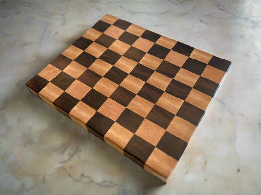 Handcrafted checkered end grain cutting board made from walnut and maple, featuring a beautiful, durable design perfect for meal prep and serving.