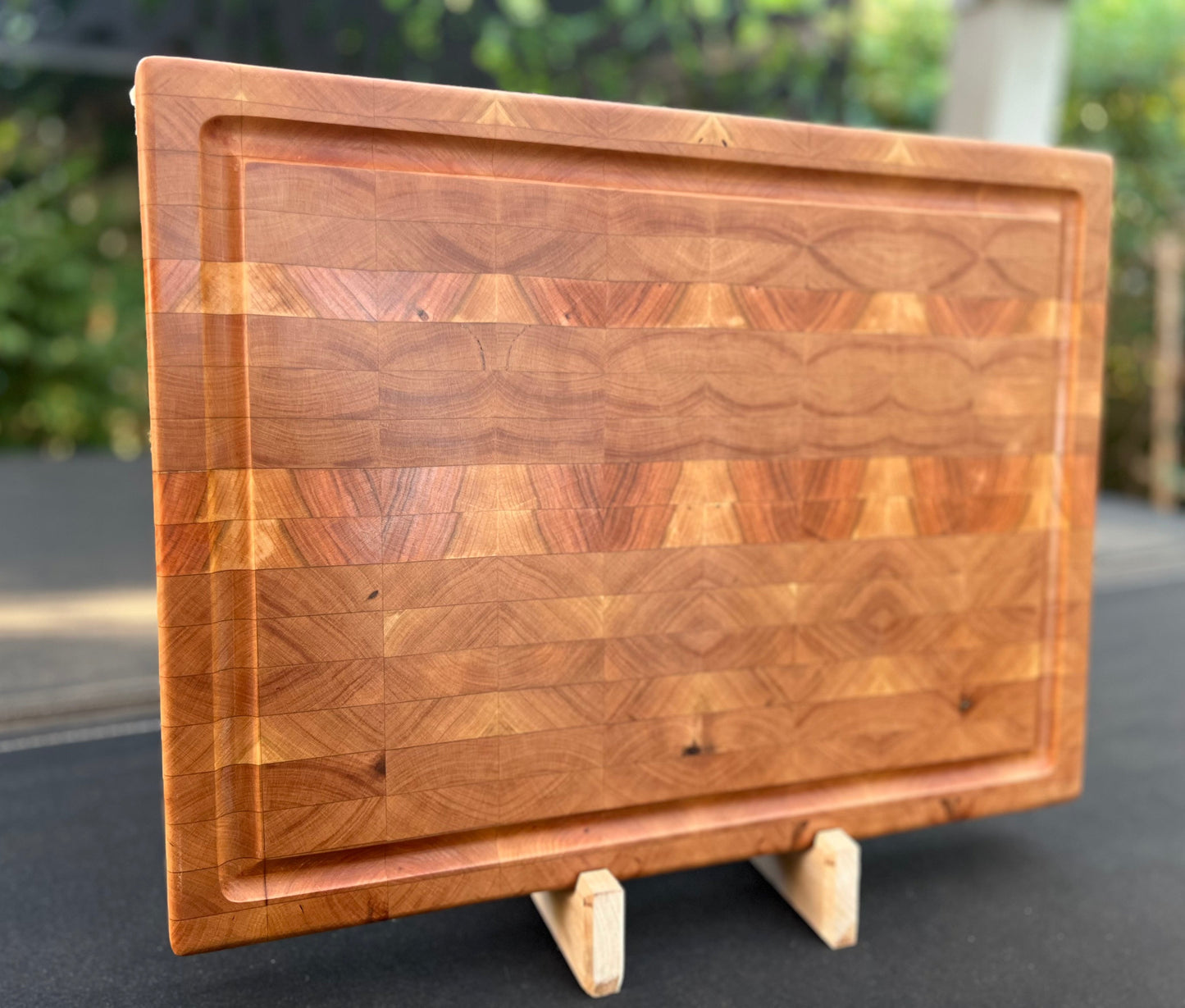 End grain cherry cutting board showcasing a rich, warm wood grain pattern and a sturdy, knife-friendly surface.