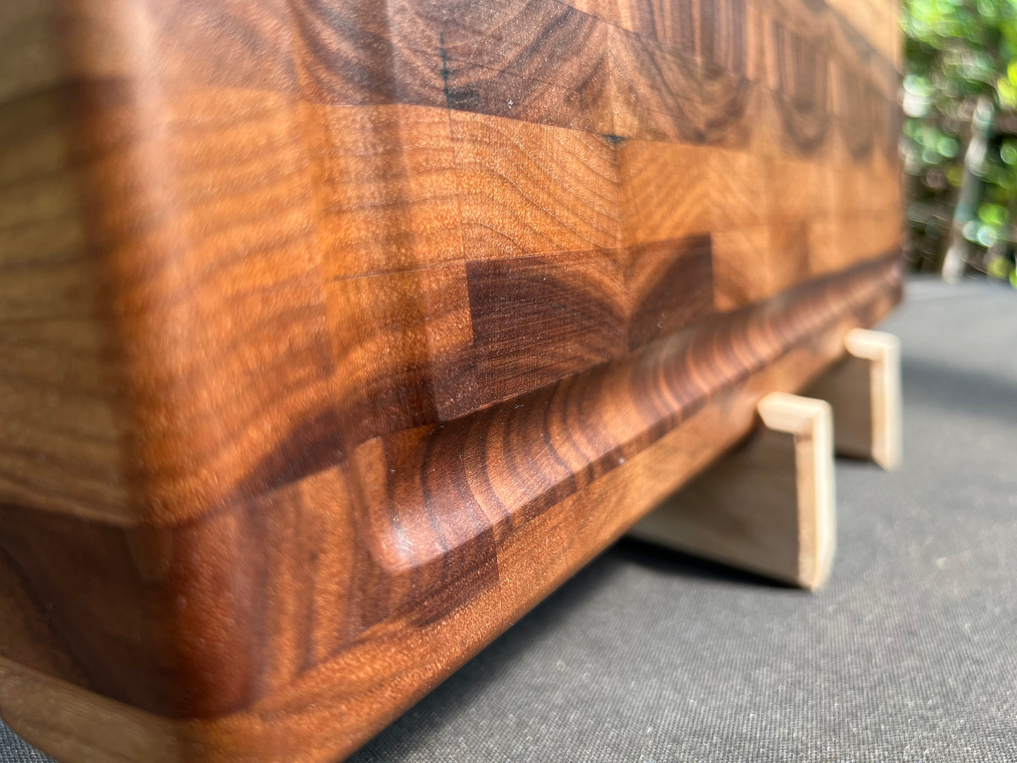 Large end grain walnut cutting board with a robust, textured surface that highlights the rich wood grain and provides durability for heavy use.